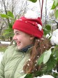 Smile girl with snowball on her red hat