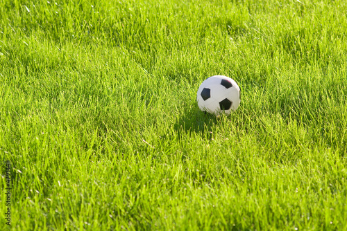 Photo: toy football on green grass toy football on green grass