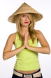 The young woman in a straw hat on a white background. Hands toge