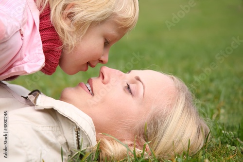 daughter looking at his mother on green grass daughter looking at his mother on green grass
