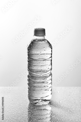 Photo: Wet water bottle on a reflective tabletop Wet water bottle on a reflective tabletop