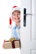 Boy with Santa's Hat peeking behind the door