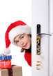 Girl with Santa's Hat peeking behind the door