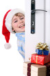 Boy with Santa's Hat peeking behind the door