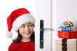 Girl with Santa's Hat peeking behind the door