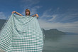 Woman extending a tablecloth .