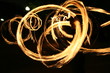 Poi dance performance with fire circular patterns