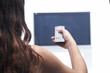 Woman with remote control and flat tv
