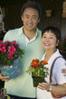 Man with mother holding flowers in nursery, portrait