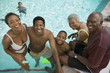 Boy 7-9 at swimming pool with parents and grandparents, elevated view portrait.
