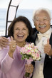 Couple at wedding giving thumbs-up, smiling, portrait