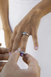 Groom putting wedding ring on brides finger, close-up