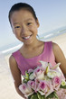 Young Bridesmaid with flowers on beach, portrait