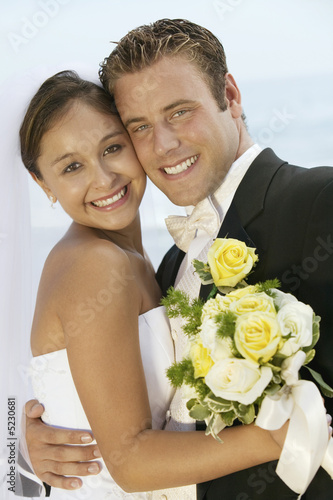 Foto: Bride and Groom Hugging on Beach Bride and Groom Hugging on Beach