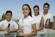 Tennis Family on court by net, daughter holding trophy, portrait