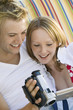 Young couple sitting on sofa looking at video camera screen, close up