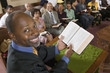 Photo: Preacher at altar holding open Bible in Front of Congregation, portrait, high angle view Preacher at altar holding open Bible in Front of Congregation, portrait, high angle view