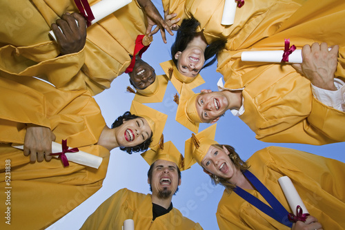 Photo: Group of graduates holding diplomas outside, view from below Group of graduates holding diplomas outside, view from below