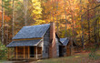 Photo: Log cabin in a wooded setting during the autumn season Log cabin in a wooded setting during the autumn season