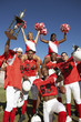 Photo: Football players and cheerleaders holding up trophy Football players and cheerleaders holding up trophy