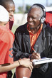 Football Coach with clipboard Talking to Players