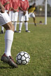 Soccer player taking free kick, low section