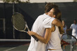Tennis Players holding rackets, Hugging at Net, side view