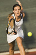 Tennis Player Reaching to hit tennis ball on tennis court
