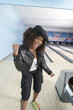 Young woman at bowling alley celebrating, portrait