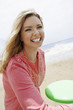 Young woman playing Frisbee on beach