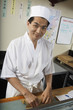 Sushi chef preparing plate of sushi in restaurant