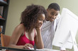Photo: Couple at desk looking at computer screen Couple at desk looking at computer screen