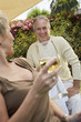 Photo: Elegant couple smiling to each other at garden party Elegant couple smiling to each other at garden party