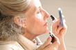 Woman applying makeup to her face. Woman applying makeup to her face.