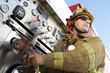 Fire fighter connecting hose to fire truck instrument panel