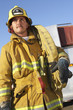 Fire fighter standing with hose on shoulder