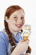 Overweight girl 13-15 smiling, holding ice cream cone, portrait
