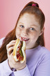Overweight girl 13-15 Eating hot dog, portrait, close-up