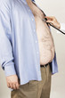 Doctor hand with stethoscope on overweight man's heart, side view, mid section