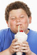 Overweight boy 13-15 drinking milk shake, eyes closed, front view