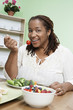 Overweight woman eating healthy food, portrait
