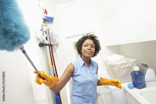Foto: Woman dusting at home Woman dusting at home