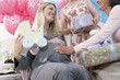 Friends giving gifts to woman at baby shower