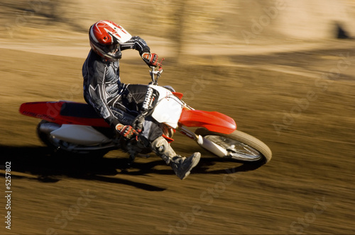 Photo: Motocross racer on dirt track Motocross racer on dirt track