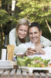 Photo: Couple embracing at outdoor table, portrait Couple embracing at outdoor table, portrait