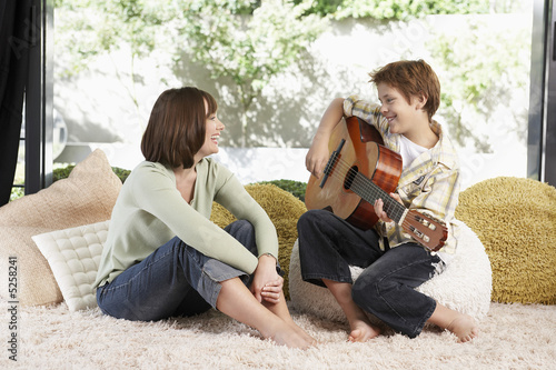 Photo: Mother listening to son play guitar Mother listening to son play guitar