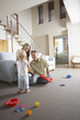 Parents sitting in living room, watching son Playing with toys