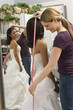 Seamstress measuring bride.