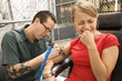 Photo: Man tattooing woman. Man tattooing woman.