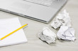 Foto: Crumpled paper and notebook on desk by laptop, close up Crumpled paper and notebook on desk by laptop, close up
